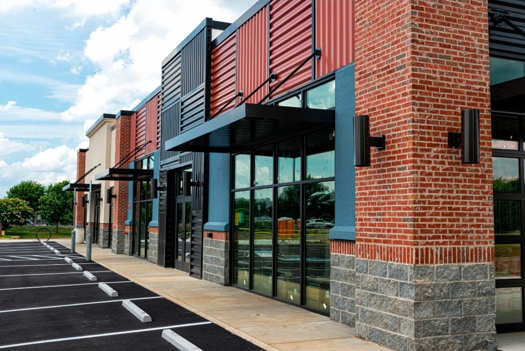 Multi-tenant commercial retail center with brick, metal panel and glass storefronts