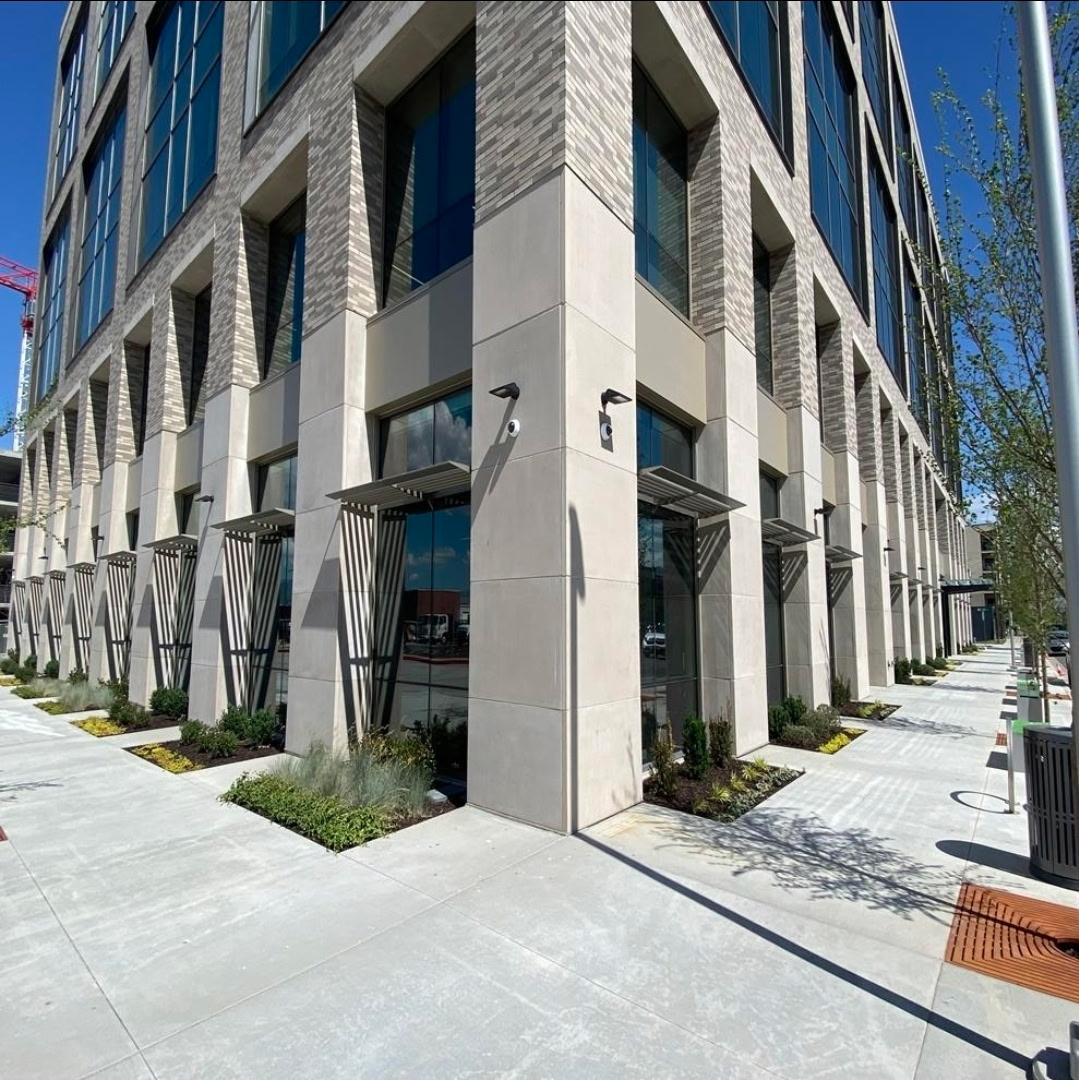 Modern commercial mid-rise with limestone, brick and floor-to-ceiling glass storefront