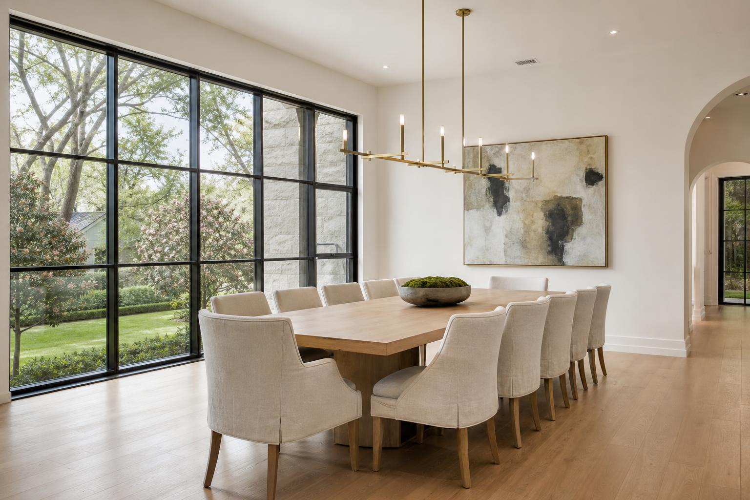 Highland Park formal dining room with white oak table, brass linear chandelier and floor-to-ceiling steel windows